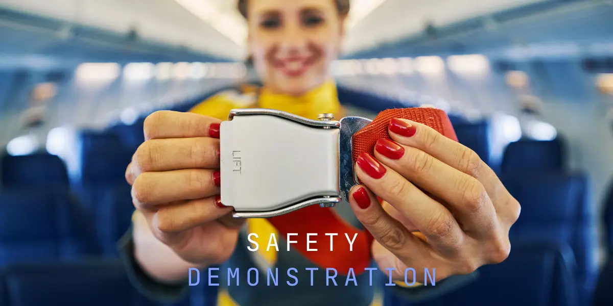 flight attendant safety demonstration with passengers on airplane