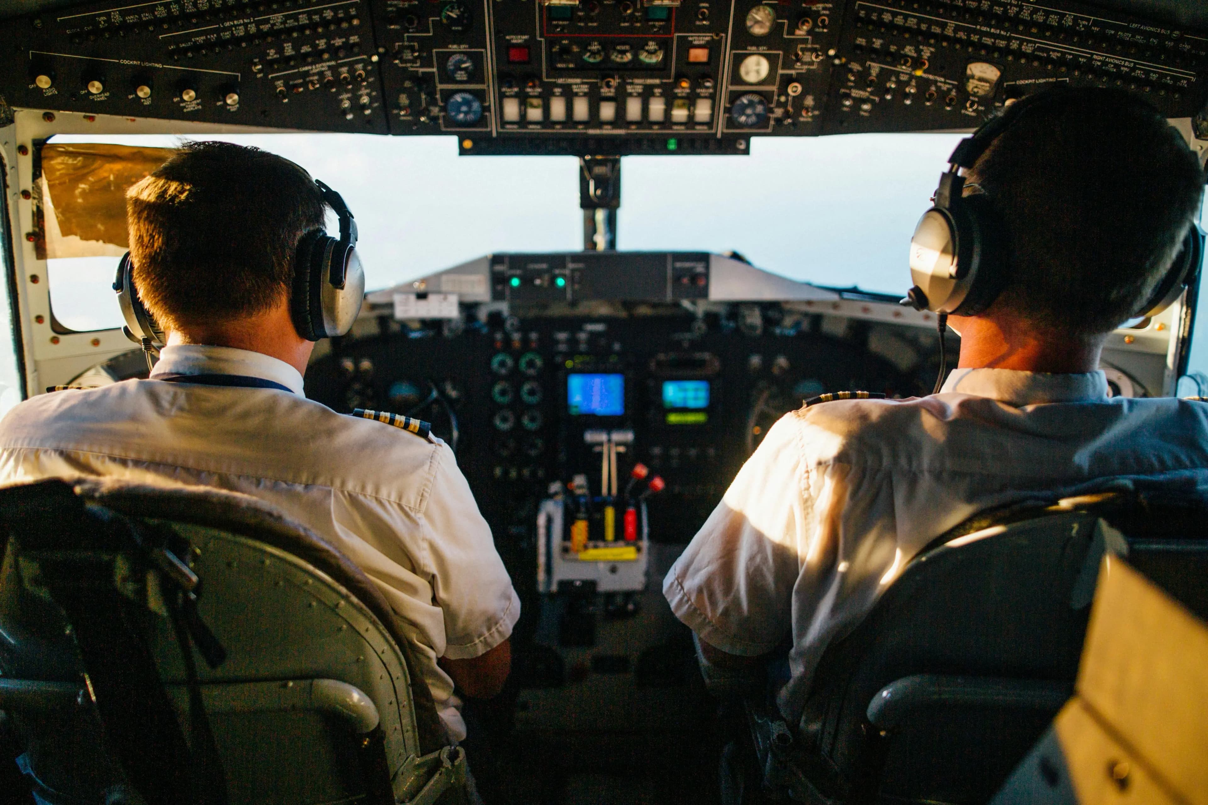 two pilots in cockpit navigating airplane at high altitude